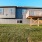 Pet-Friendly Homes for Rent in Belton, MO - Elm Grove - Backyard with Manicured Grass, Wood Deck, and View of Property Exterior.