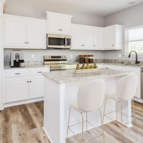 Belton, MO Rental Homes - Elm Grove - Kitchen with Luxury Vinyl Plank Flooring, White Shaker-Style Cabinets, Samsung Stainless Steel Appliances, Granite Countertops, and a Kitchen Island